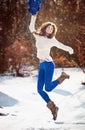 Attractive brunette girl with white sweater posing playing in winter scenery. Beautiful young woman with long hair enjoying snow