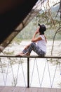 Attractive brunette in a hat and white shirt is enjoying nature in the mountains. Beautiful young woman in a shirt and Royalty Free Stock Photo