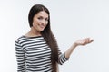 Attractive brunette raising arm while demonstrating something Royalty Free Stock Photo