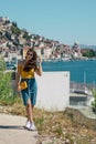 Attractive brunette wearing a blue skirt and an orange top posing outside near the sea on a warm summer day. Long hair flowing in Royalty Free Stock Photo