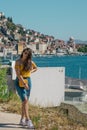 Attractive brunette wearing a blue skirt and an orange top posing outside near the sea on a warm summer day. Long hair flowing in Royalty Free Stock Photo