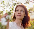 Attractive brunette in a white dress near a flowering Apple tree Royalty Free Stock Photo