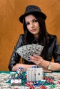 Attractive brunette woman with dollar fan in casino