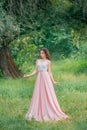 attractive brunette woman enjoying nature in delicate elegant pink silk dress Royalty Free Stock Photo