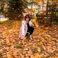 attractive brunette woman holds colorful maple leaves. Lady enjoys autumn nature and relaxes