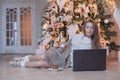 Attractive brunette woman with laptop at home. Christmas and New Year holidays concept Royalty Free Stock Photo