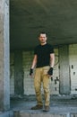 Attractive brutal man in black in an abandoned building. Stalker, lover of extreme adventures Royalty Free Stock Photo