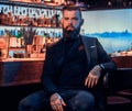 Attractive brutal man is sitting near bar counter