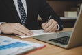 Attractive business man in black suit working and writing on document report on desk in meeting room Royalty Free Stock Photo