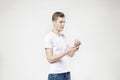 Attractive business man model in white t-shirt isolated on white calling by mobile phone, push buttons hand touching screen
