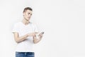 Attractive business man model in white t-shirt isolated on white calling by mobile phone, push buttons hand touching screen.