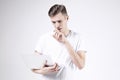 Attractive business man model in white t-shirt isolated on white working with laptop in right hand. Thinking about start-up projec