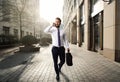 Attractive business man walks through berlin while talking on his smart phone Royalty Free Stock Photo