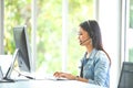 Attractive business woman Asian in suits and headsets are smiling while working with computer at office. Customer service Royalty Free Stock Photo