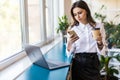 Attractive business woman drinking coffee in her office. Pretty young business woman having coffee at her workplace. Female Royalty Free Stock Photo