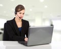 Attractive business woman with headset working on a laptop Royalty Free Stock Photo