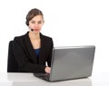 Attractive business woman with headset working on a laptop Royalty Free Stock Photo