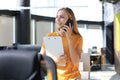 Attractive business woman talking with collegues on the mobile phone while sitting on the office desk Royalty Free Stock Photo