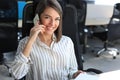 Attractive business woman talking with collegues on the mobile phone while sitting in the office desk Royalty Free Stock Photo