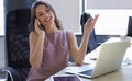 Attractive business woman talking with collegues on the mobile phone while sitting in the office desk Royalty Free Stock Photo