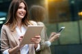 Attractive business woman using a digital tablet while standing in front of windows in an office Royalty Free Stock Photo