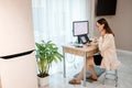 Attractive business woman wearing casual clothes working at home office on laptop and making notes. Young happy female student Royalty Free Stock Photo