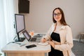 Attractive business woman wearing casual clothes working at home office on laptop and making notes. Young happy female student Royalty Free Stock Photo