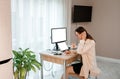 Attractive business woman wearing casual clothes working at home office on laptop and making notes. Young happy female student Royalty Free Stock Photo