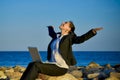 Attractive business woman working on laptop at beach