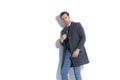 Attractive businessman arranging his coat and posing with attitude Royalty Free Stock Photo