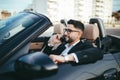 Attractive businessman with convertible car, using mobile Royalty Free Stock Photo