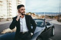 Attractive businessman with convertible car, using mobile Royalty Free Stock Photo
