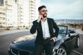 Attractive businessman with convertible car, using mobile Royalty Free Stock Photo