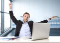 Attractive businessman happy and hectic at office work sitting at computer desk satisfied celebrating Royalty Free Stock Photo