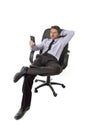 Attractive businessman leaning relaxed sitting on office chair networking on mobile phone Royalty Free Stock Photo