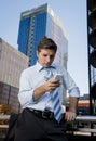 Attractive businessman looking text message at mobile phone outdoors Royalty Free Stock Photo