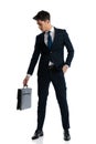 attractive businessman in navy blue suit looking down at his suitcase Royalty Free Stock Photo