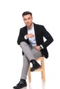 Attractive businessman sitting on wooden chair with legs crossed Royalty Free Stock Photo