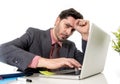 attractive businessman in suit and tie working in stress at office computer laptop looking desperate and frustrated in work and b