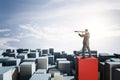 Attractive businessman with telescope standing on abstract blocks and looking into the distance on bright sky background with mock Royalty Free Stock Photo