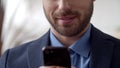 Attractive businessman texting on cell phone. Smiling man texting on smartphone. Royalty Free Stock Photo