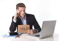 Attractive businessman working in stress at computer holding help cardboard sign Royalty Free Stock Photo