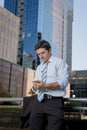 Attractive businessman writing text message at mobile phone outdoors Royalty Free Stock Photo