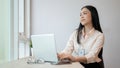 An attractive businesswoman is daydreaming about her happy career path while working on her laptop Royalty Free Stock Photo