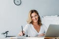 attractive businesswoman holding pen and looking at camera Royalty Free Stock Photo