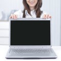 Attractive businesswoman presenting a laptop with copyspace on the monitor Royalty Free Stock Photo