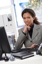 Attractive businesswoman sitting at desk in office Royalty Free Stock Photo