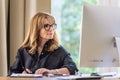 Attractive businesswoman sitting at home and using computer for work Royalty Free Stock Photo