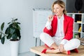 attractive businesswoman sitting on table and biting glasses