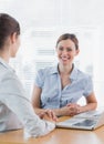 Attractive businesswoman smiling at camera with her colleague Royalty Free Stock Photo